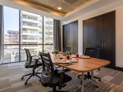Small meeting room with a wooden conference table and city views reflecting vina del mar meeting room at Veranda Hotel
