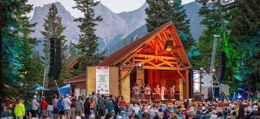 A group of travelers attend an outdoor music festival together in Canmore.