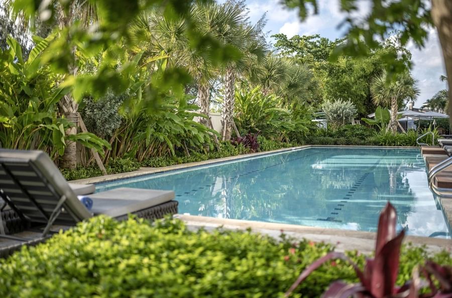 Crystal clear lap pool surrounding lush tropical greenery and palm trees at Warwick Paradise Island Bahamas