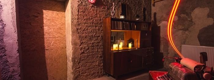 The Cipher Room with stone walls, red glow, and a vintage typewriter near Novotel Sydney International Airport