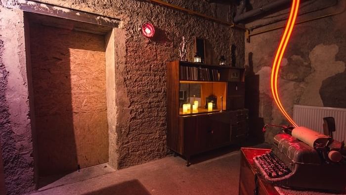 The Cipher Room with stone walls, red glow, and a vintage typewriter near Novotel Sydney International Airport