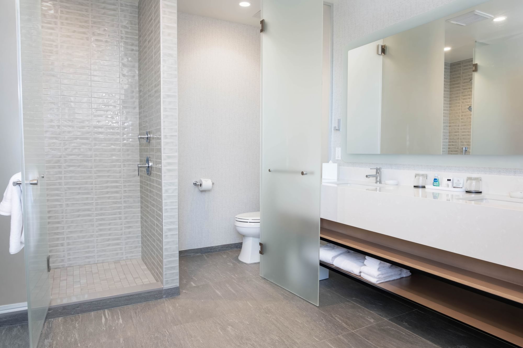 A modern bathroom with a shower, toilet, and sink area.