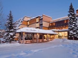 Exterior view of Legacy Vacation Resorts Steamboat featuring a covered snow covered entrance portico at dusk