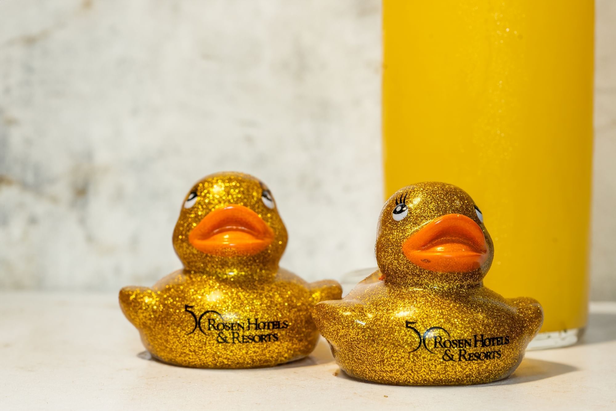 Two golden rubber ducks with the 50th anniversary logo for Rosen Hotels & Resorts on them.