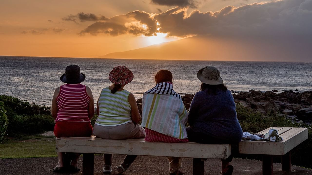 four women friends watch as the sun sets