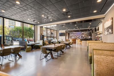 Modern interior of The Gavel at The Riverwalk Plaza Hotel with wooden furniture, large windows, and a stylish ceiling