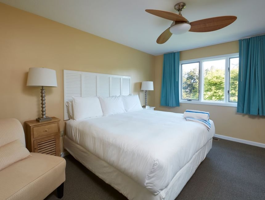Bed with table lamp by the window in Max Villas at Breezeway Boutique Hotel