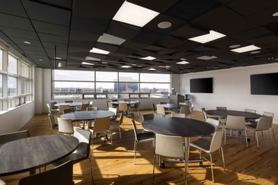 Circular tables and chairs in a large room with a city view and black ceiling at Aramark Ross