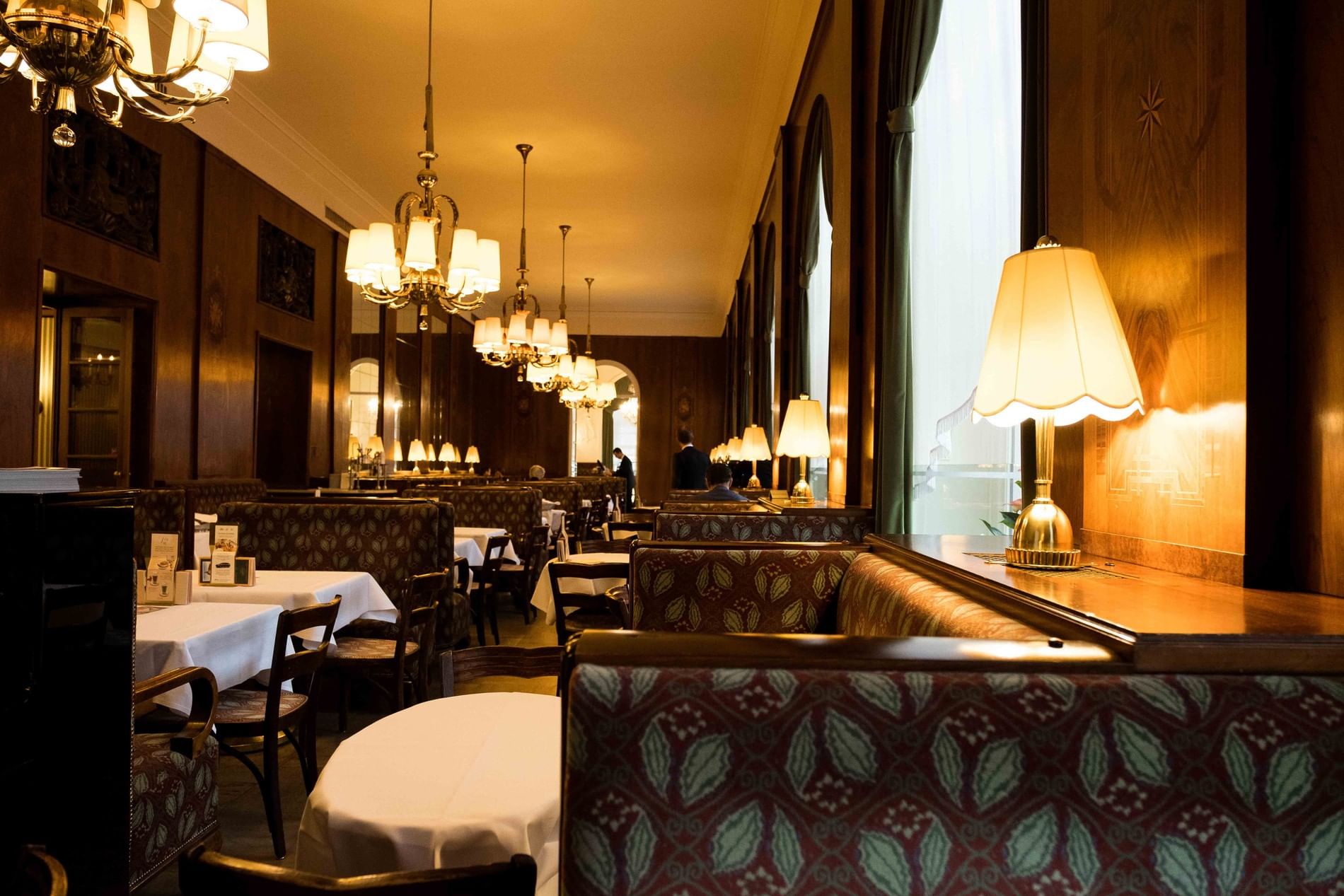 Café Landtmann in Vienna with classic coffee house interior, warm lighting and elegant seating booths