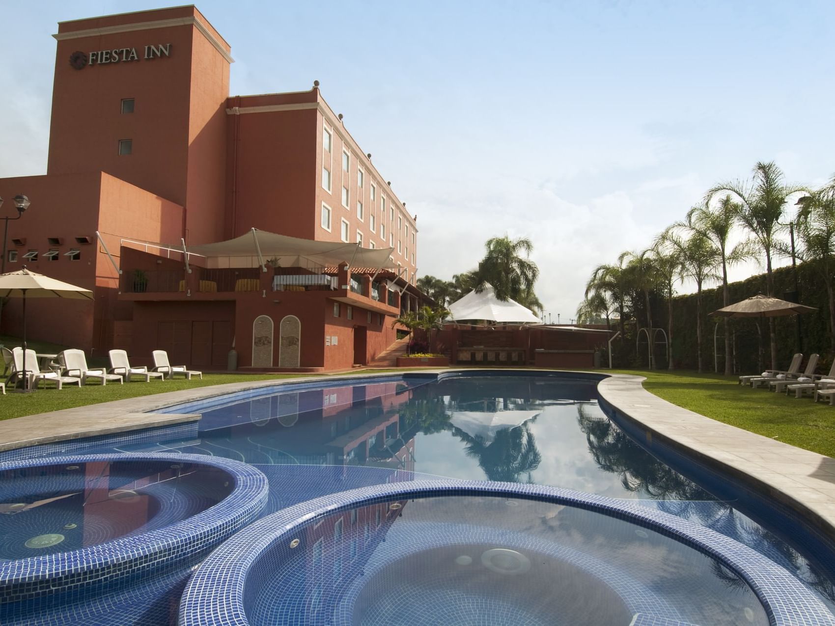 Outdoor swimming pool area & Exterior View of Fiesta Inn Hotel