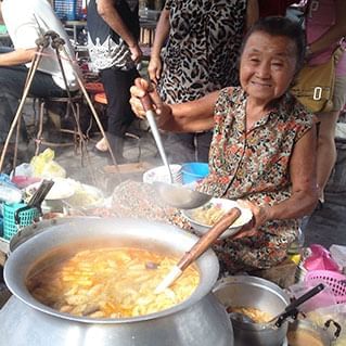 An old lady serving curry in penang