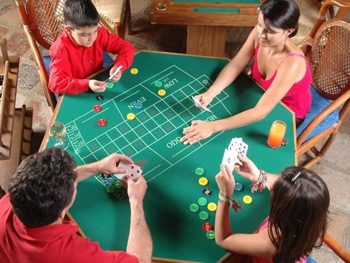 Four people playing an arcade game at Hacienda Cantalagua