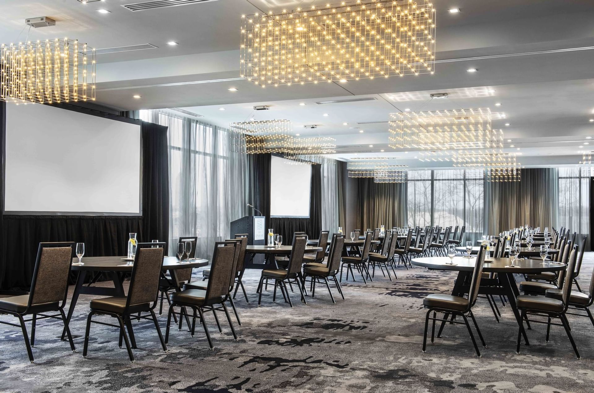 ballroom with tables, chairs and large screens