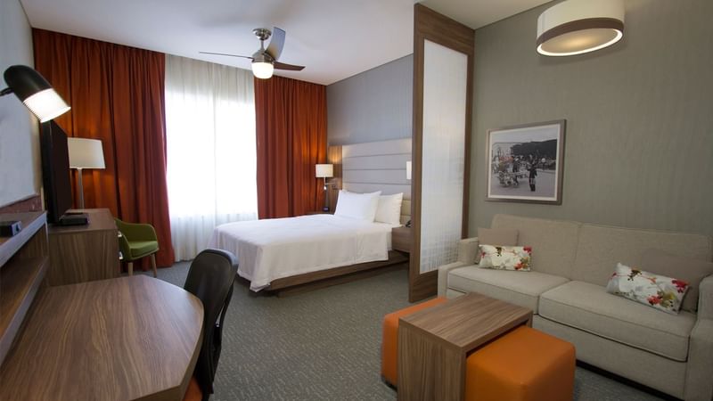 Bed with a couch and work desk in Suite Matrimoniales at Fiesta Inn Suites Aeropuerto del Bajío Silao