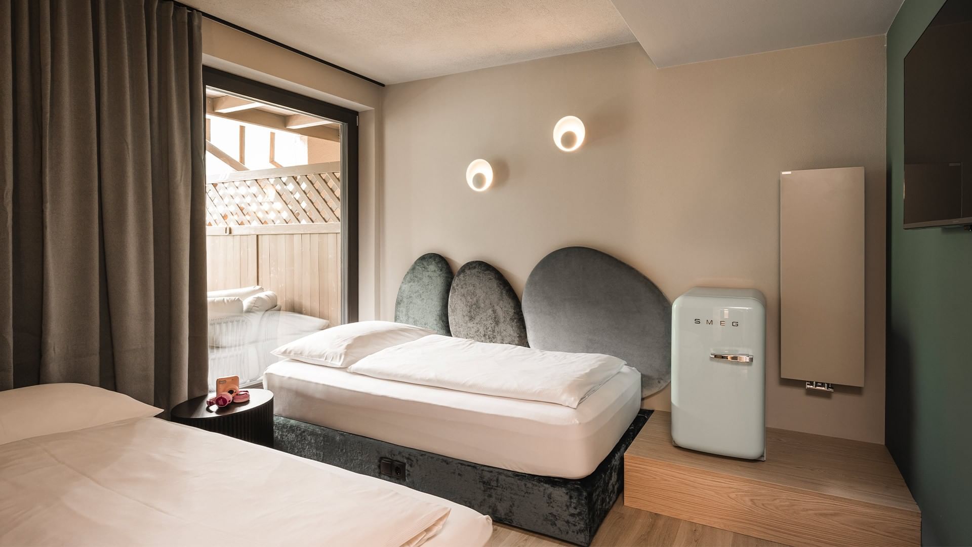 Zwei saubere, weiße Betten in einem Hotelzimmer mit einer kleinen Bar und einem Fernseher an der Wand.