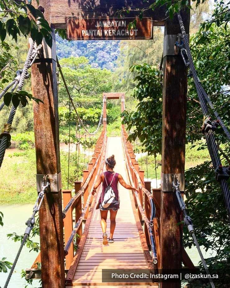 A lady walked across a wooden suspension bridge at Penang National Park - Lexis Suites Penang