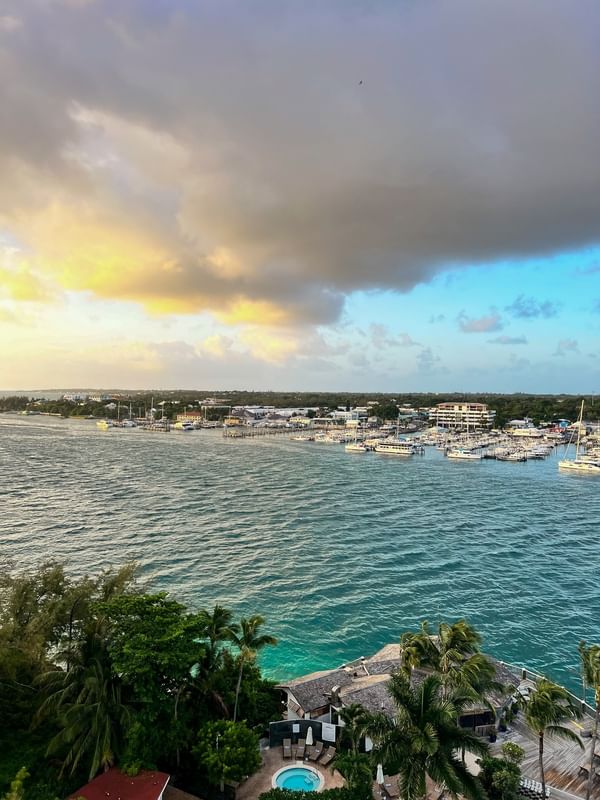 Aerial view of a harbor by a coastal town under a golden sunset near Warwick Paradise Island Bahamas