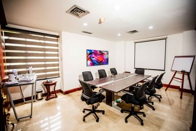 Aguacatal Meeting Room with a long table, chairs, and a projector at Dann Carlton Cali, a premier hotel in Cali Colombia