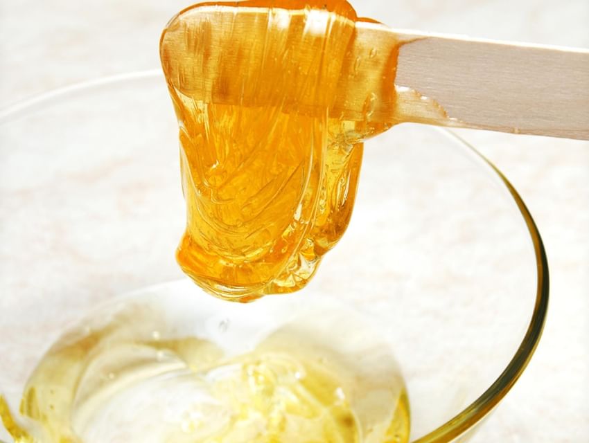 Una cuchara vierte miel en un tazón del Hotel San Fernando Plaza
