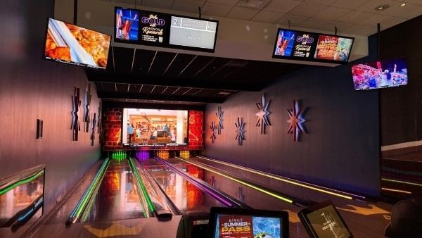 Four colorful bowling lanes surrounded by eye-catching screens at King's, a great place for families in Orlando.