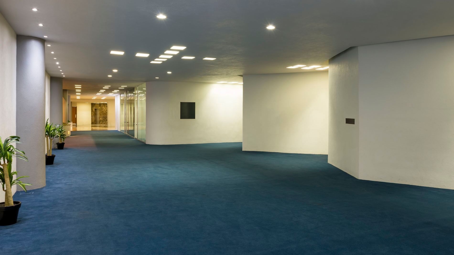 Grand ballroom set for a gala with white linens, dance floor, and striped carpets at Real Inn Nuevo Laredo