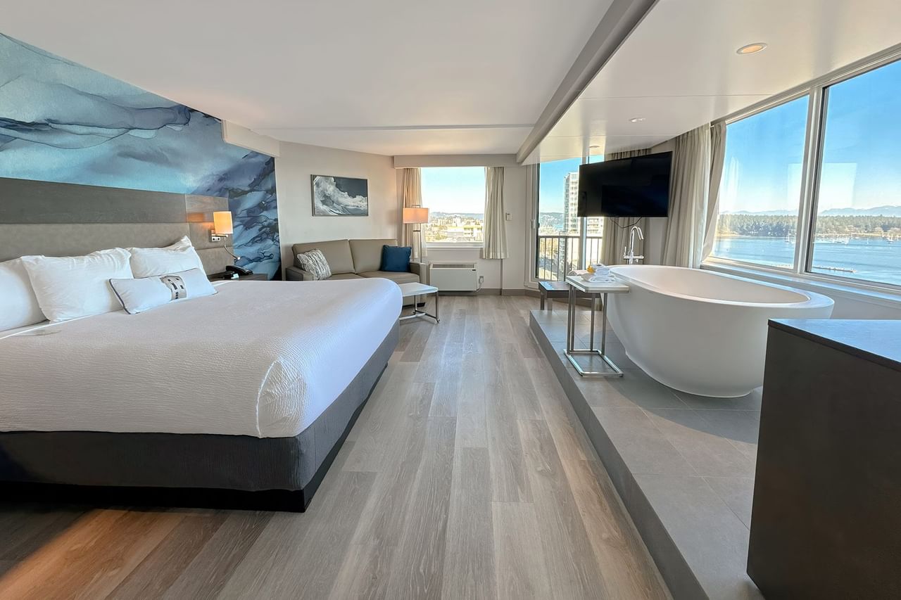 Hotel guestroom with King bed, soaker tub and a large TV