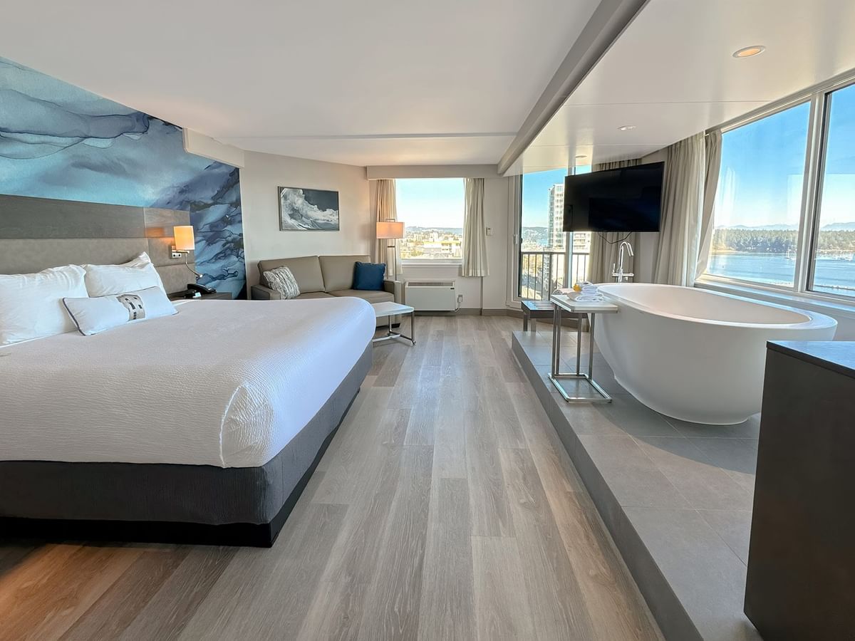 Hotel guestroom with king bed, a soaker tub and a large TV