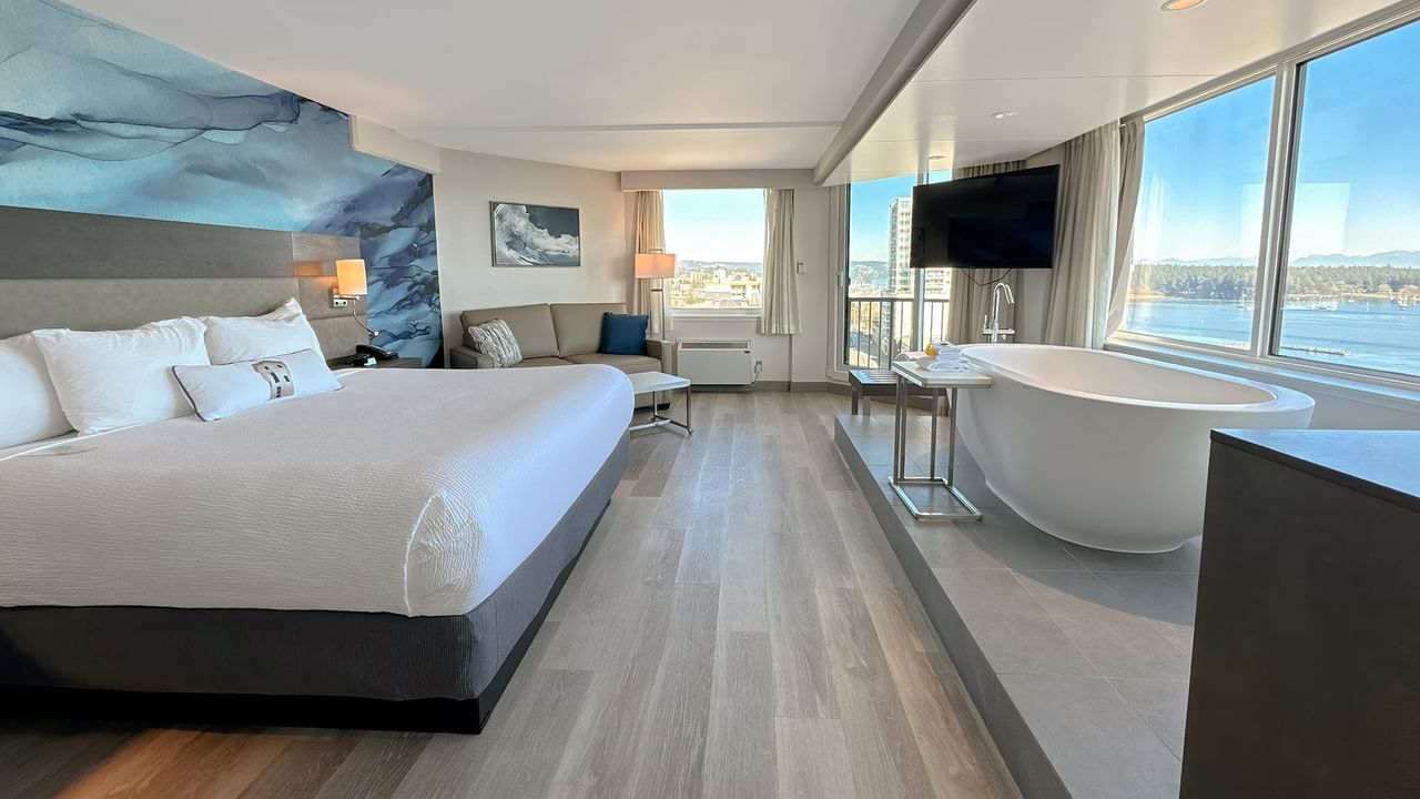 Hotel guestroom with king bed, a soaker tub and a large TV