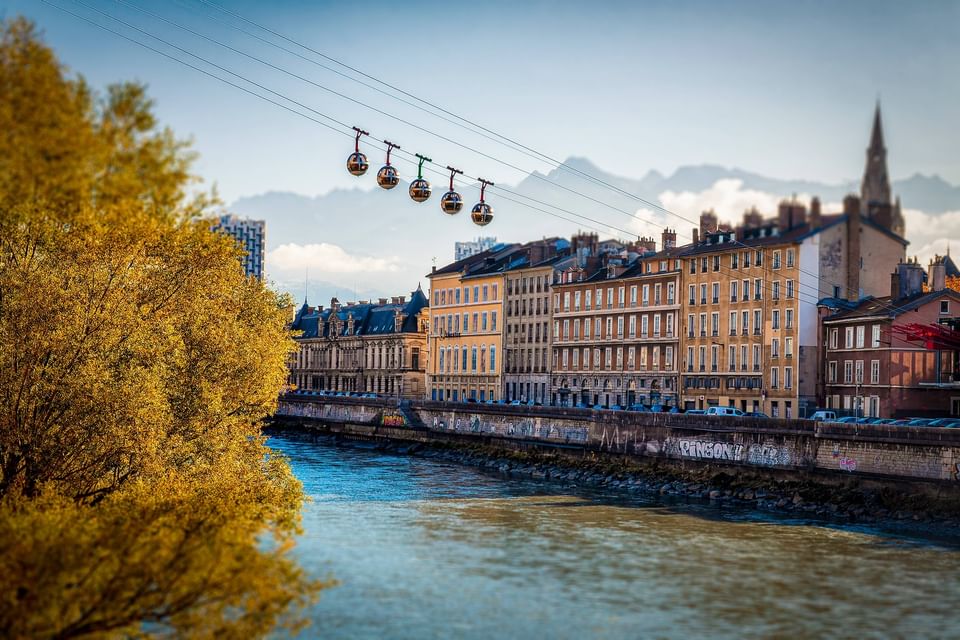 Cable cars over the river with mountains near ResidHotel Central Gare, an apartment hotel near Grenoble train station
