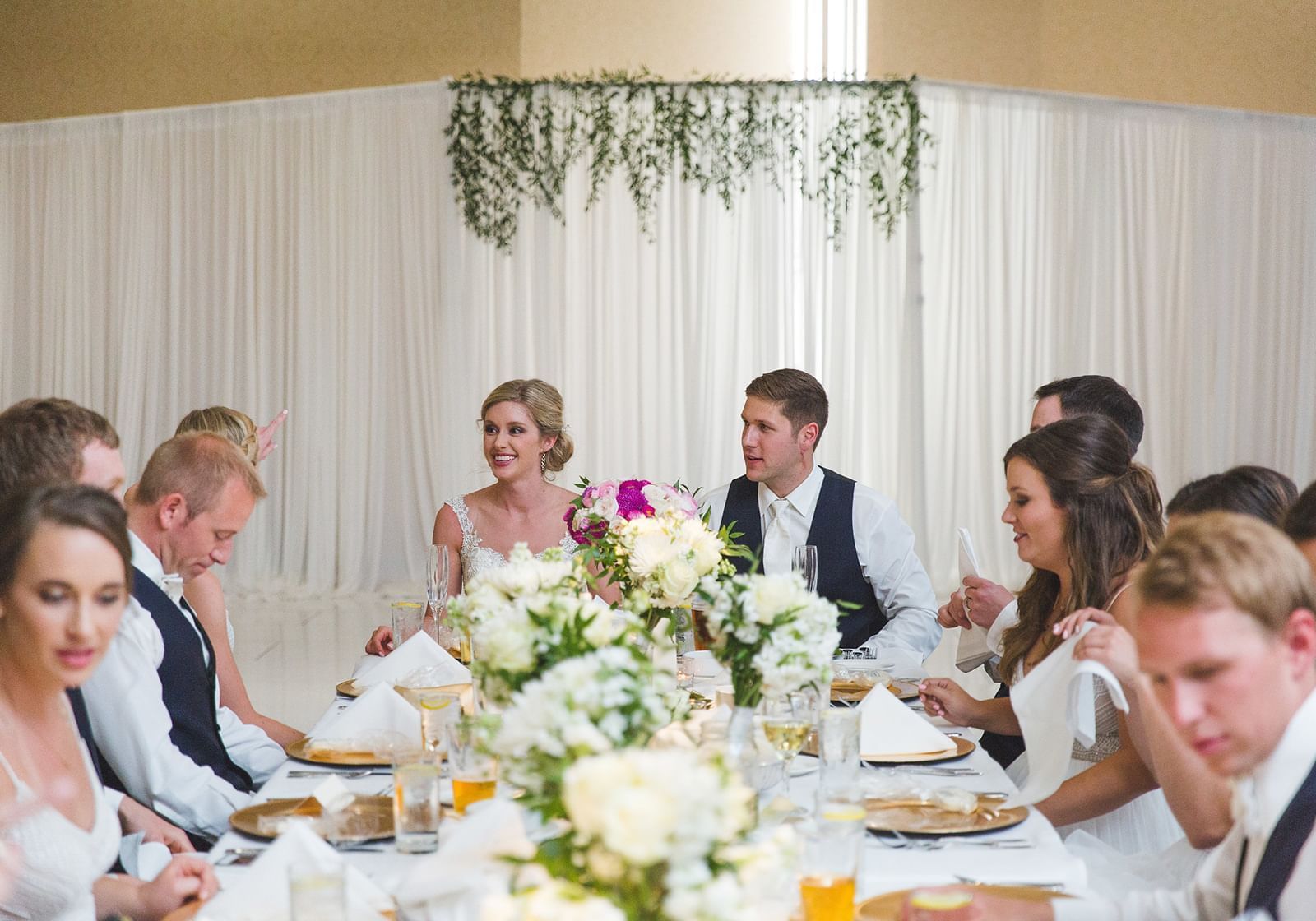 Bride and groom sit at the head of a table at The Grove Hotel