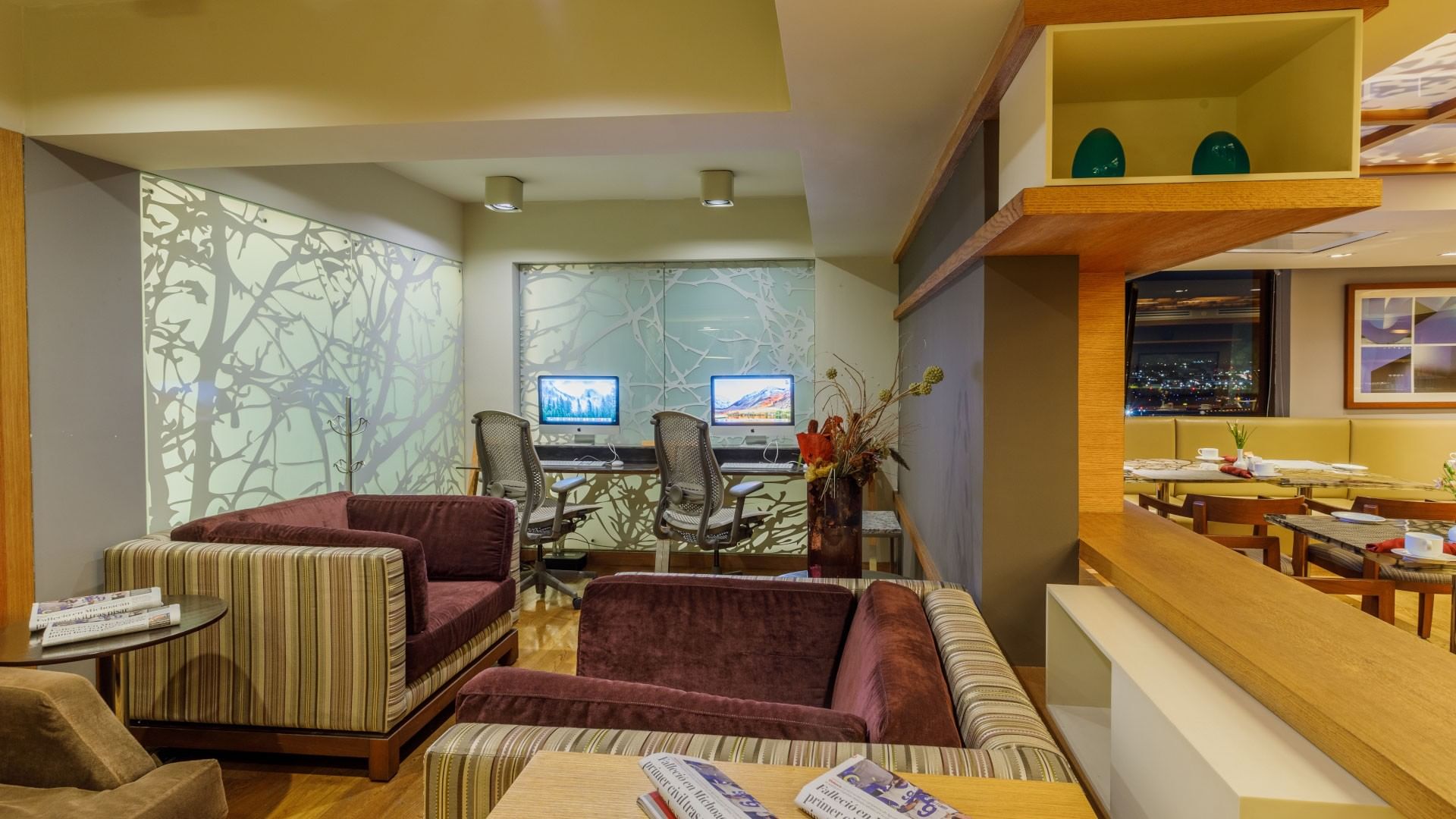 Salón de negocios acogedor con sofás y estaciones de trabajo en Camino Real Aeropuerto México en Ciudad de México