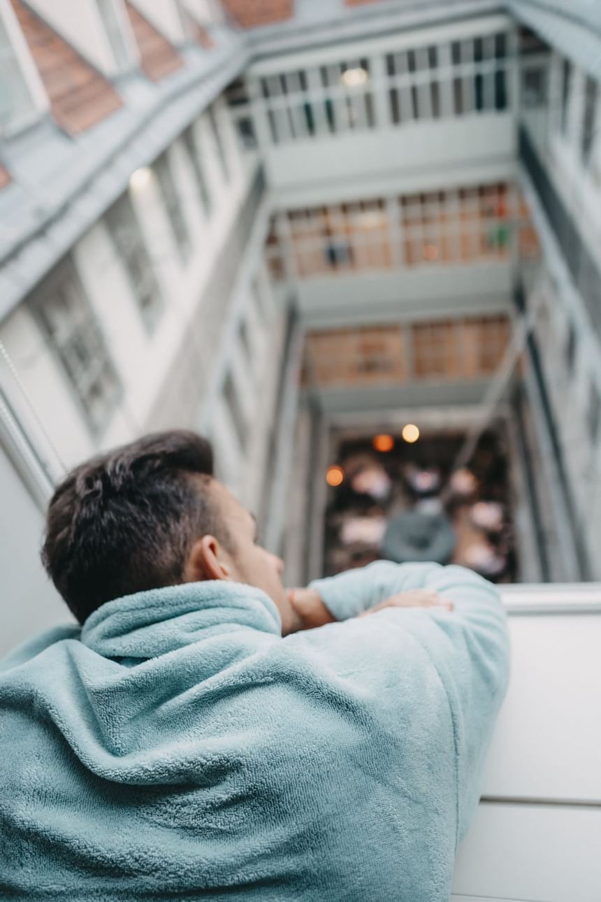 Man looks out of the window into the courtyard of the hotel in Vienna