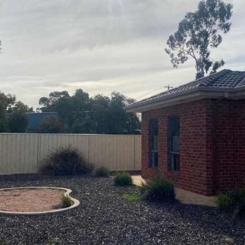 Brick house with a fenced backyard and gravel area at La Trobe University Regional Housing Mildura.