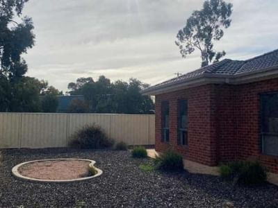 Brick house with a fenced backyard and gravel area at La Trobe University Regional Housing Mildura.