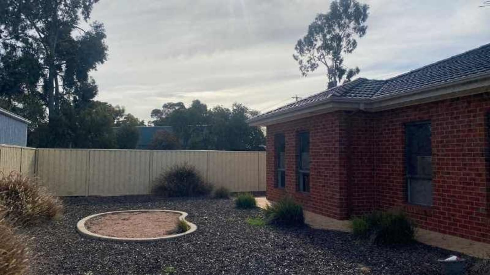 Brick house with a fenced backyard and gravel area at La Trobe University Regional Housing Mildura.