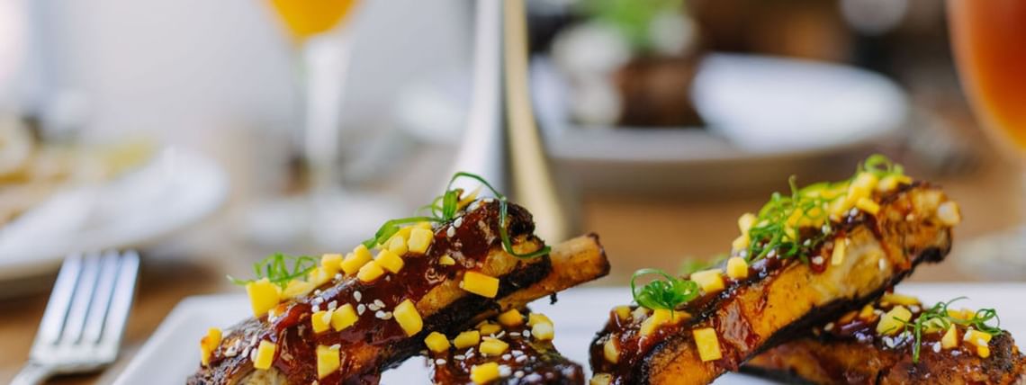 Finely plated ribs dish in a Restaurant at Dinah's Garden Hotel