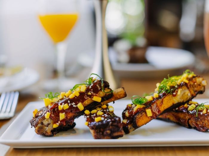 Finely plated ribs dish in a Restaurant at Dinah's Garden Hotel