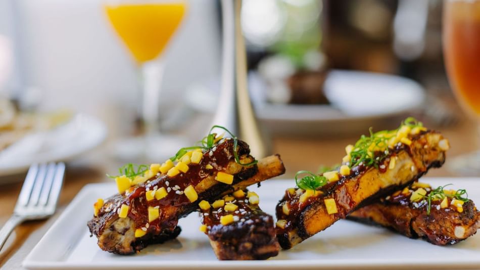 Finely plated ribs dish in a Restaurant at Dinah's Garden Hotel