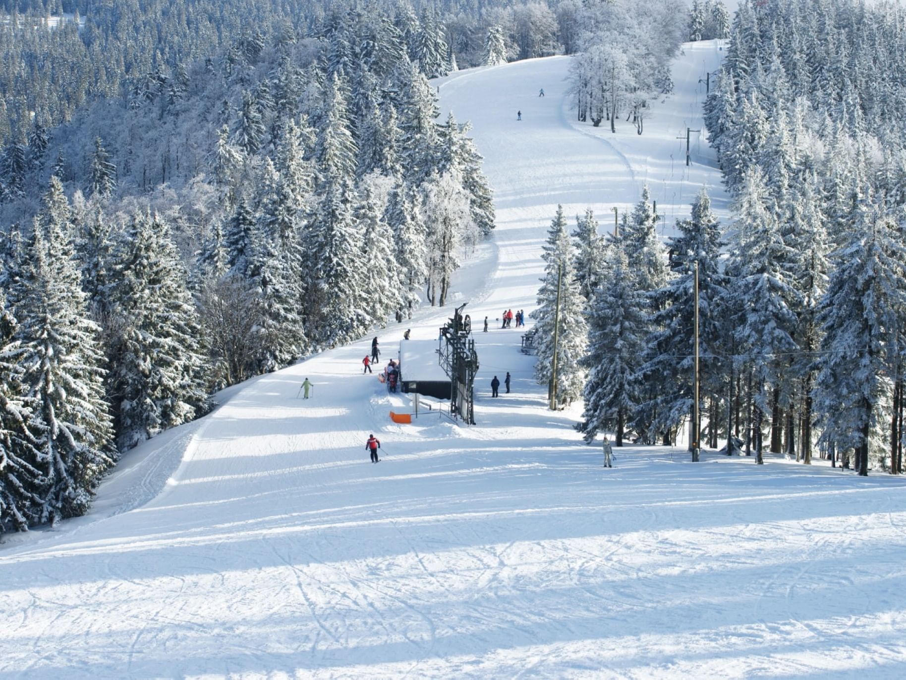Skiers enjoying the snowy terrain at Sunday River Ski Resort near The Bethel Inn Resort & Suites