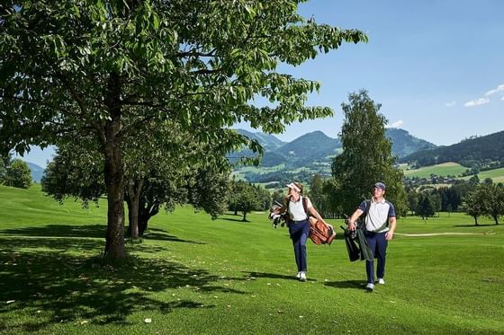 A couple on their way o play golf at Imlauer Schloss Hotel
