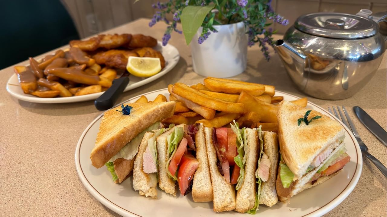 a sandwich with fries served on a plate at Green Gables Restaurant & Lounge