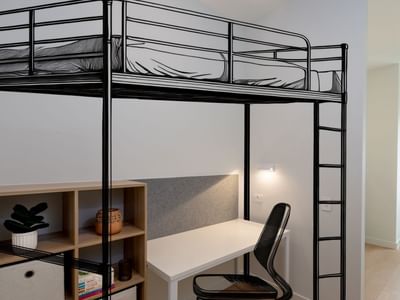 Bunk bed with desk and chair in a room at UniLodge Brisbane City.