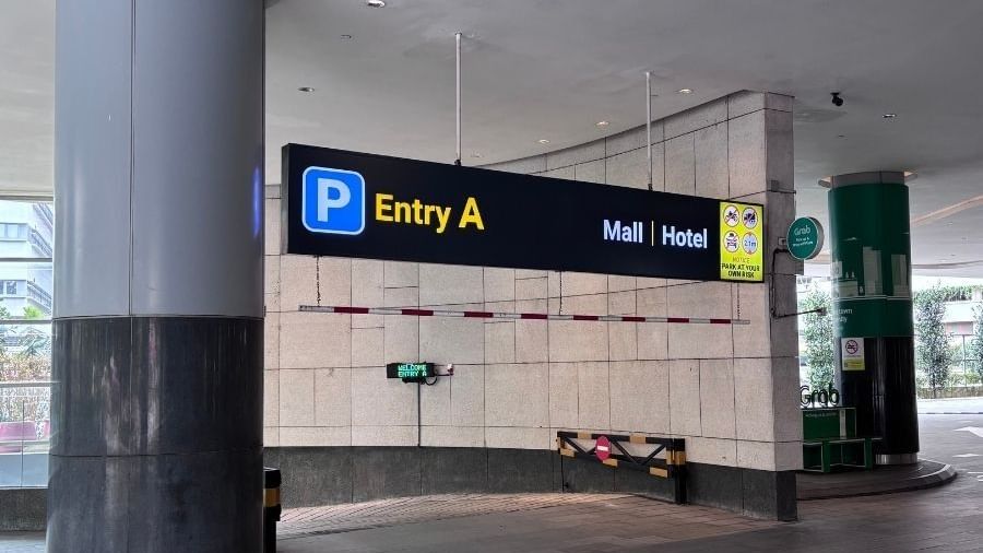 Entry A sign above a parking entrance with a red and white striped gate and a green welcome sign.