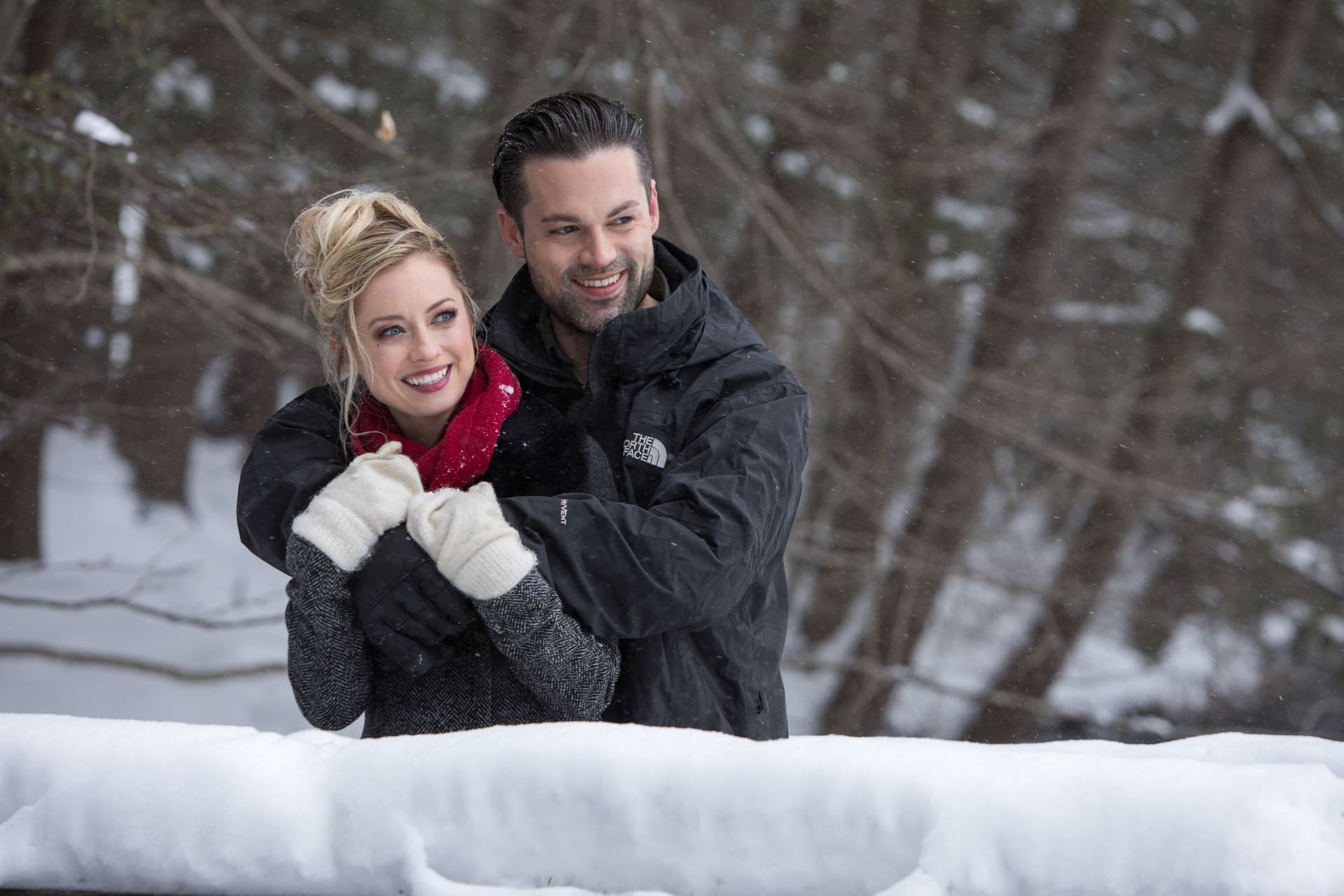 Couple embraces warmly in a snowy forest near Cove Pocono Resorts