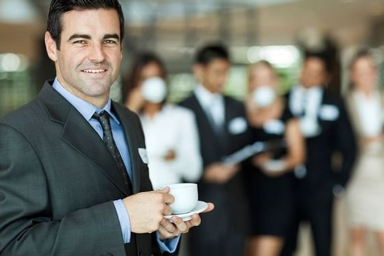 Guy in a business suit drinking coffee