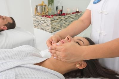 Una señora recibiendo un masaje facial en el Spa del Hotel Dann Carlton Medellín