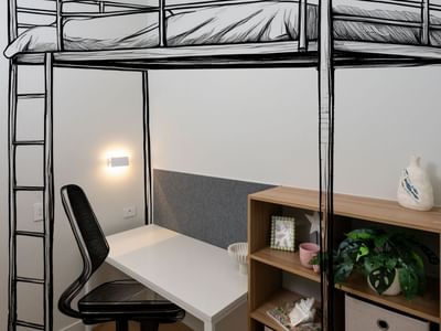 Bunk bed, desk, chair, and bookshelf in a room at UniLodge Brisbane City.