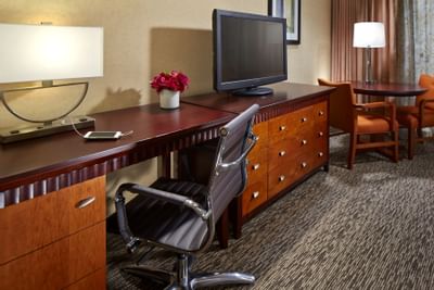 TV on the cupboard with a work desk in 2 Queen Deluxe Rooms at Anaheim Portofino Inn & Suites