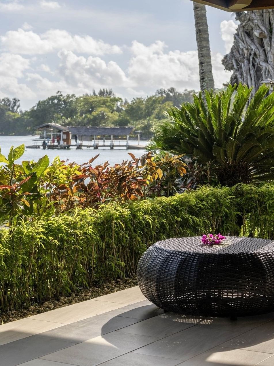 Relaxing outdoor terrace with black wicker furniture overlooking a calm lake in Erakor Residence at warwick le lagon-vanuatu