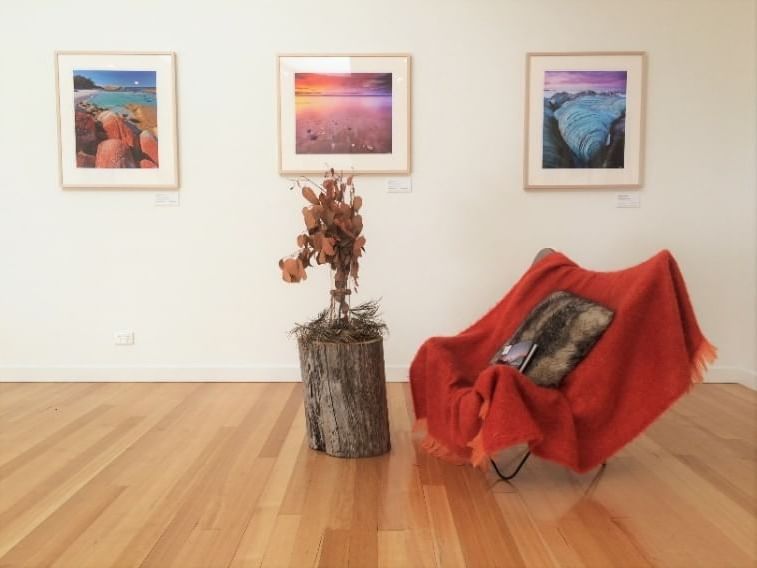 Room with a chair and sceneries at  Cradle Mountain Hotel